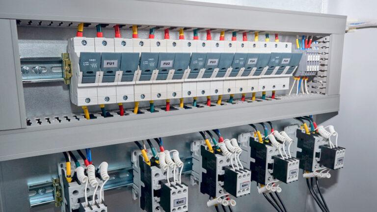 Series of Fuse holders, contactors or magnetic starters with front additional contacts, cylindrical capacitors in the electric reactive power compensation Cabinet. Wires are connected to the project.