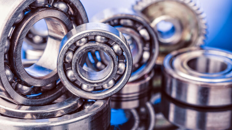Group of various ball bearings close up on nice blue background with reflections.